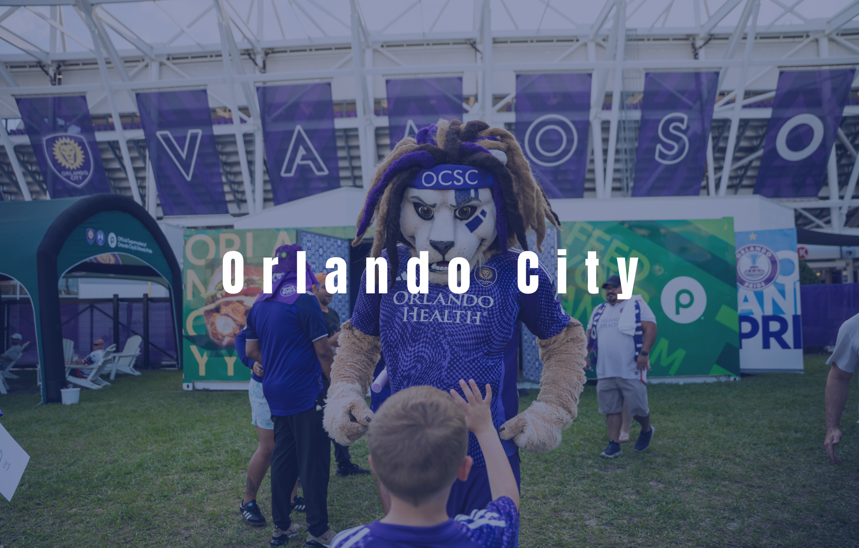 Orlando City soccer mascot interacting with fans during an outdoor team event at the stadium.